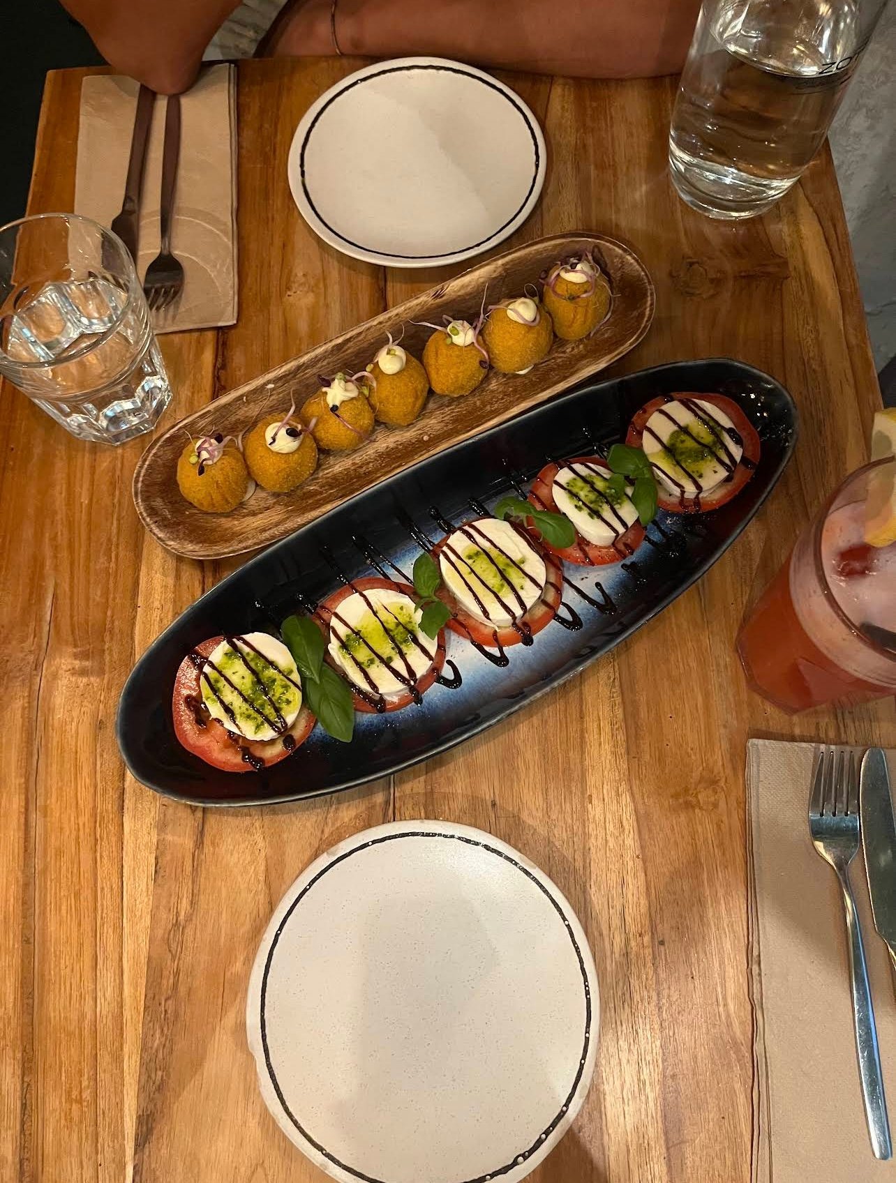 Entradas — caprese e arancini servidos na mesa da Fabbrica